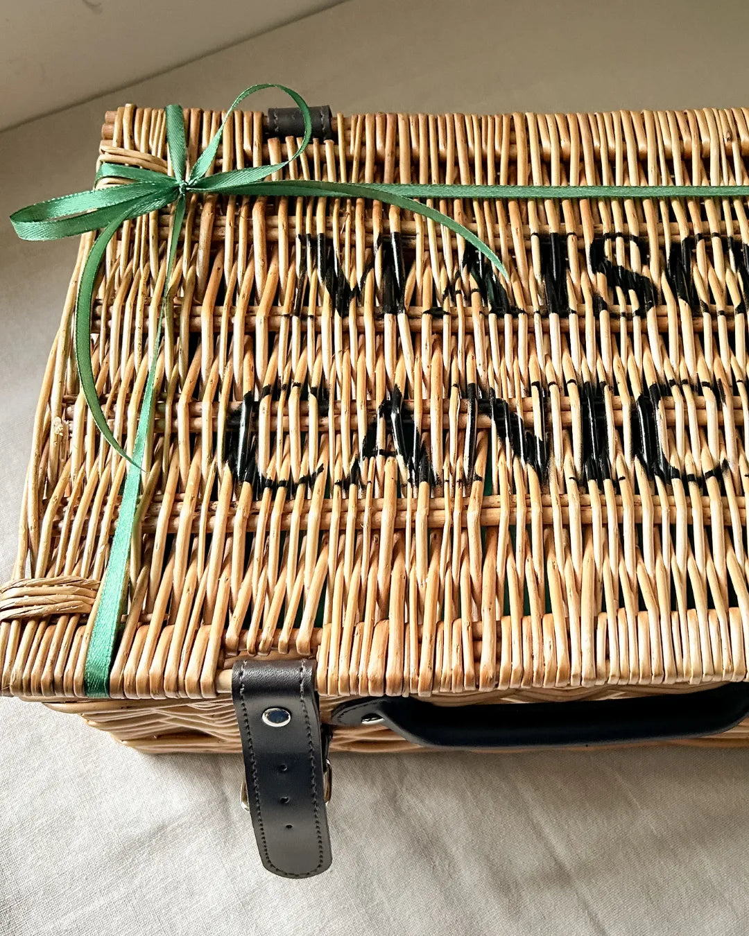 Luxury wicker hamper with 'Maison Caniche' branding and a green ribbon.