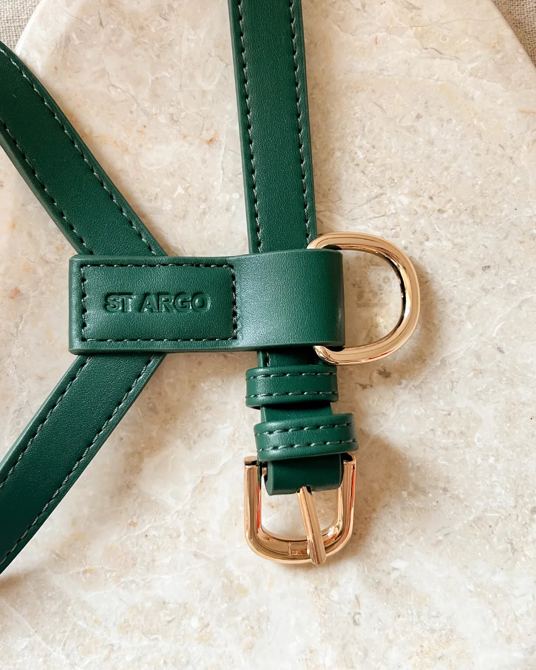 Luxury dark green vegan leather dog harness with gold hardware on a beige background