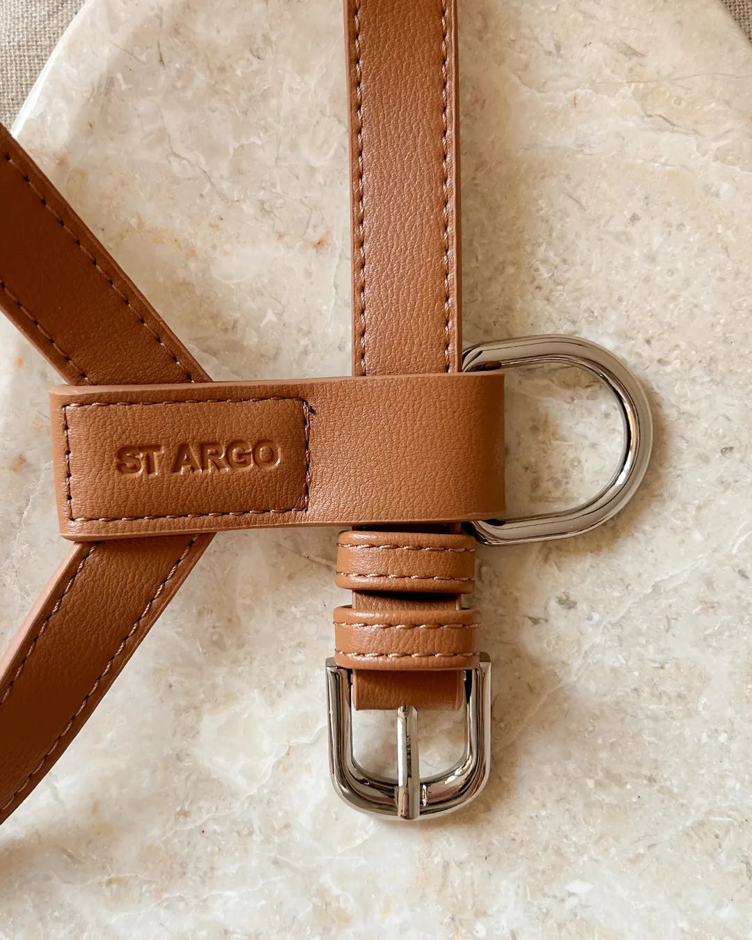 Brown vegan leather luxury dog harness with silver buckle on a beige background