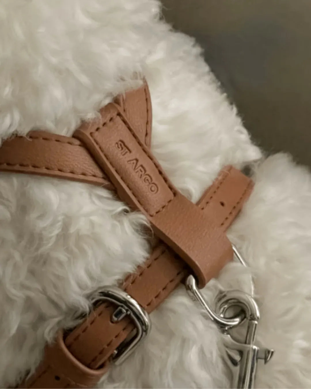 Brown vegan leather luxury dog harness with metal buckle on a fluffy white dog