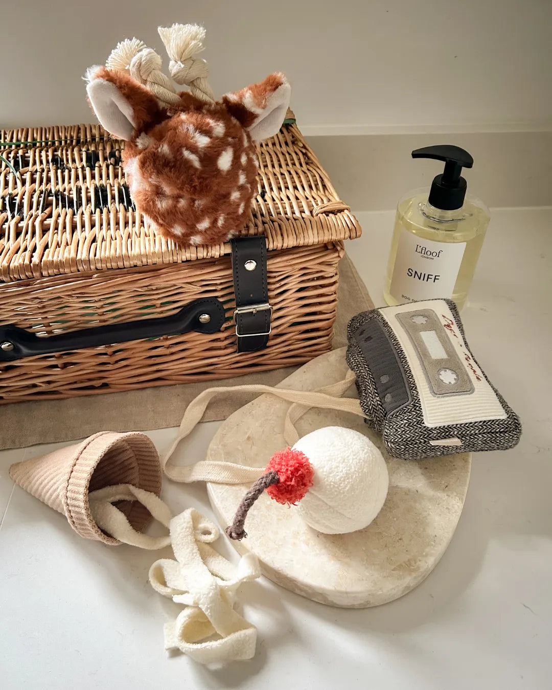 Collection of pet toys and a gift hamper on a white surface