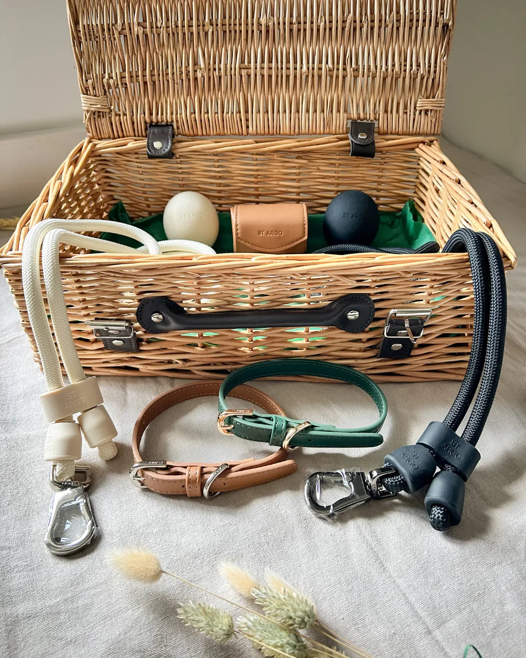 Luxury wicker hamper with neutral dog accessories on a neutral background