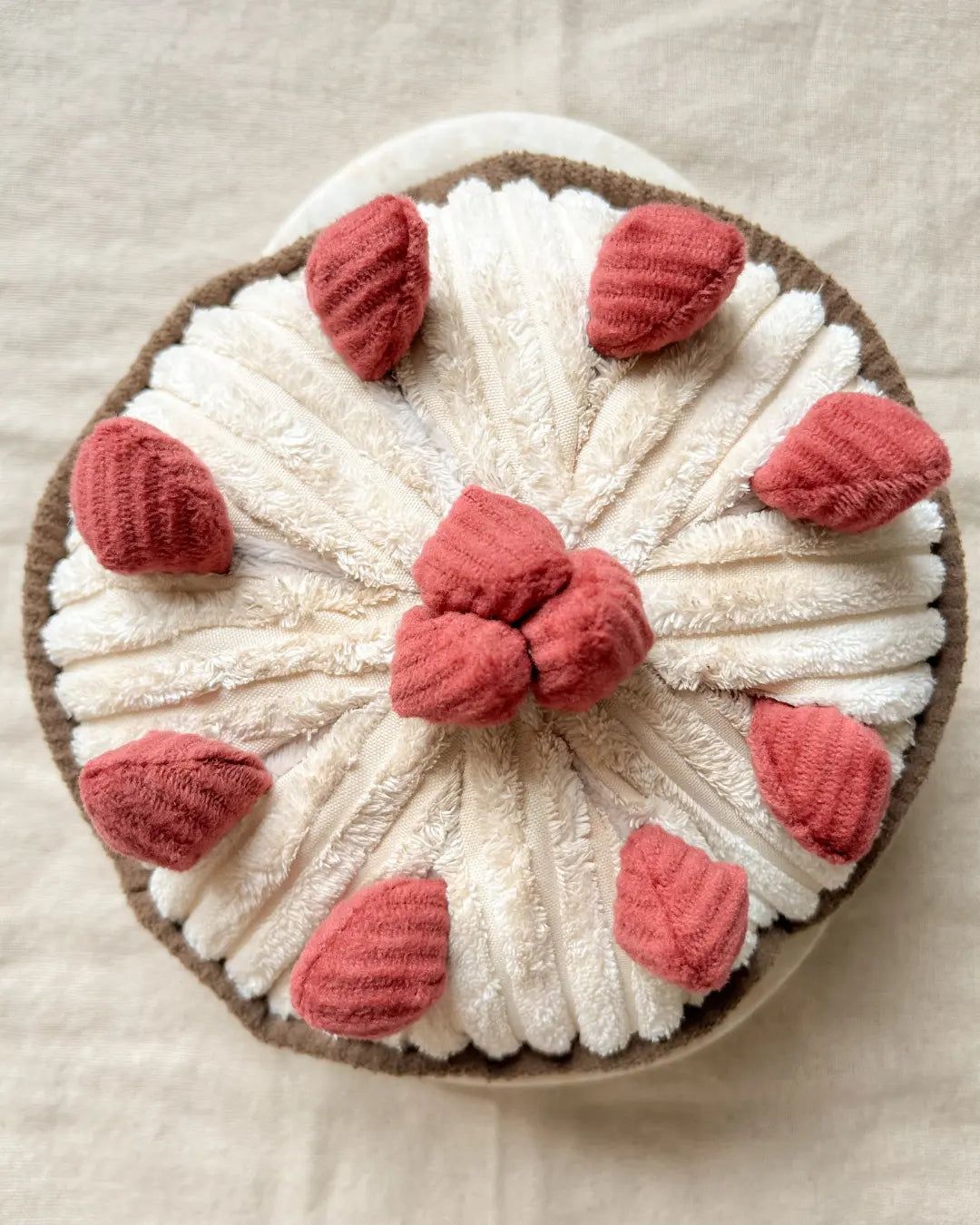 Round berry pie plush dog toy with red strawberries on a beige background