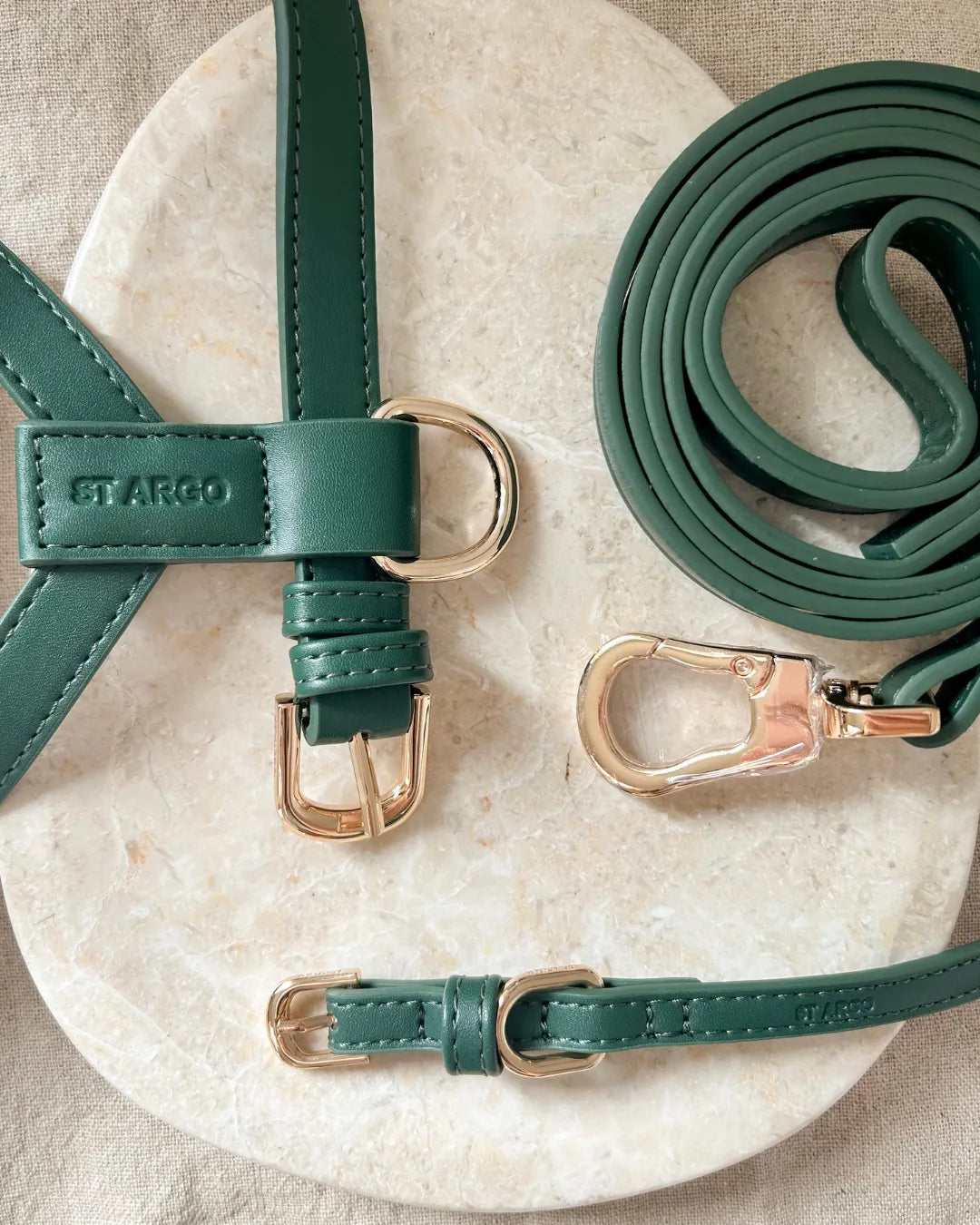 Green luxury vegan leather dog collar, harness and lead set on a marble surface