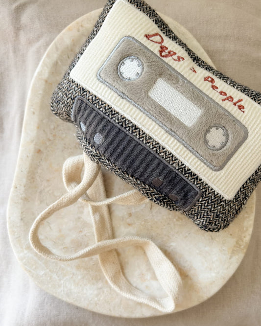 Cassette shaped dog enrichment toy with 'Dogs over People' text on a beige background