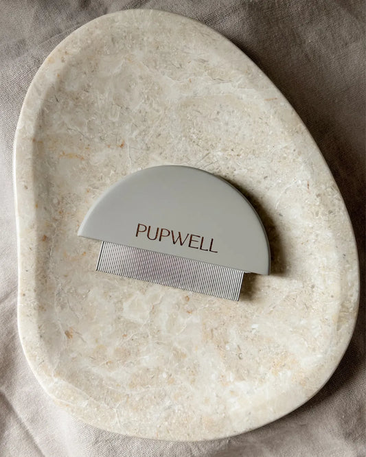 Pupwell grooming tool on a stone surface