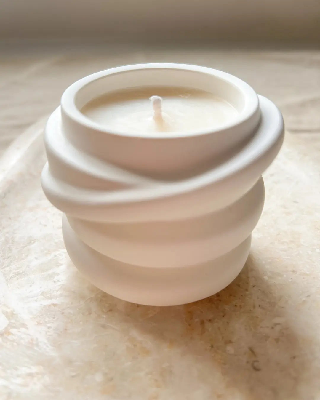 Ceramic white candle on a textured surface