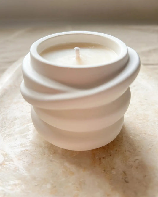 Ceramic white candle on a textured surface