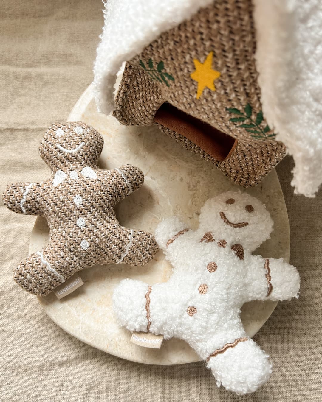 Two dog toy gingerbread men on a beige marble surface with a textured background