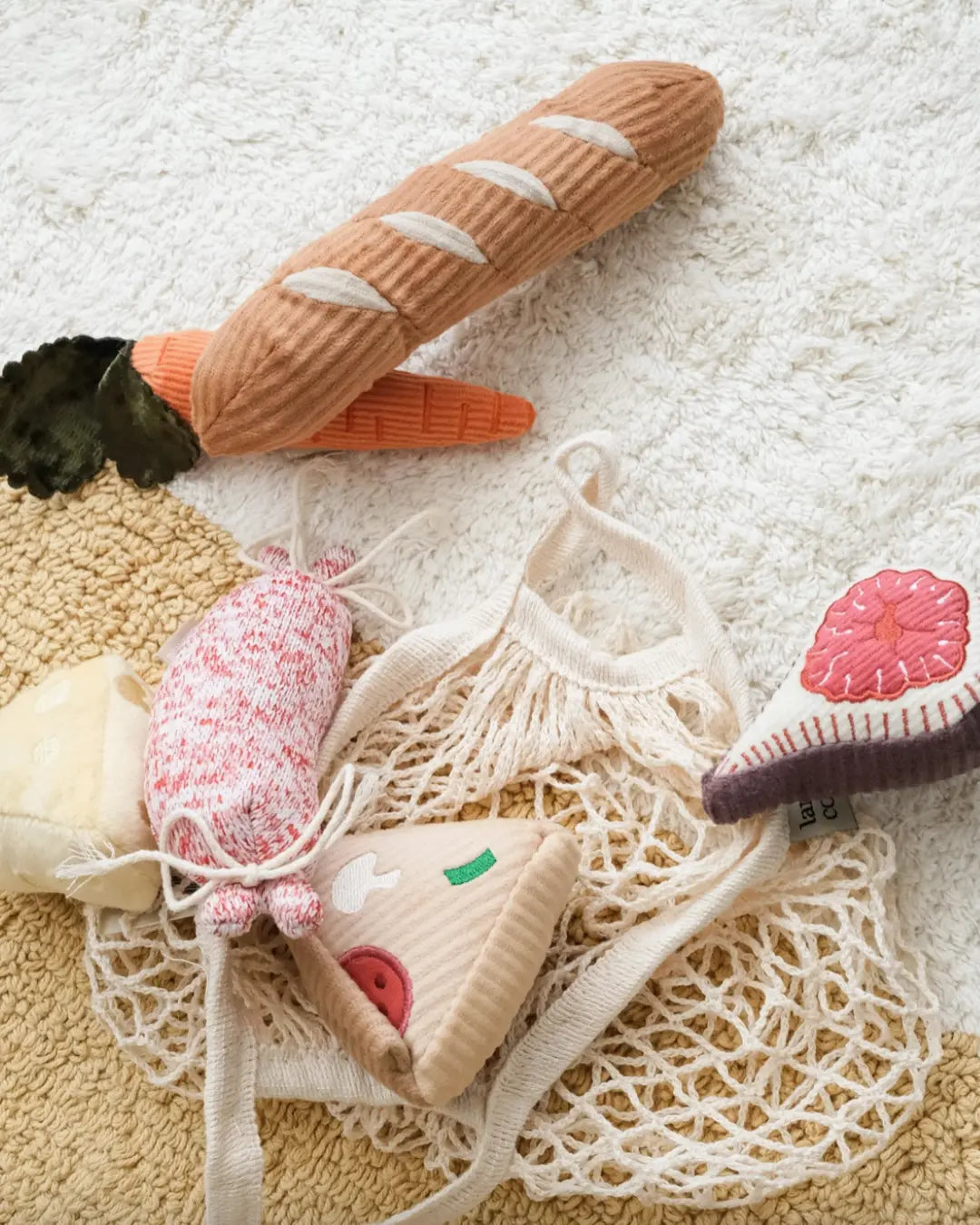 Set of dog toy vegetables including a carrot, fig, and cheese on a textured surface