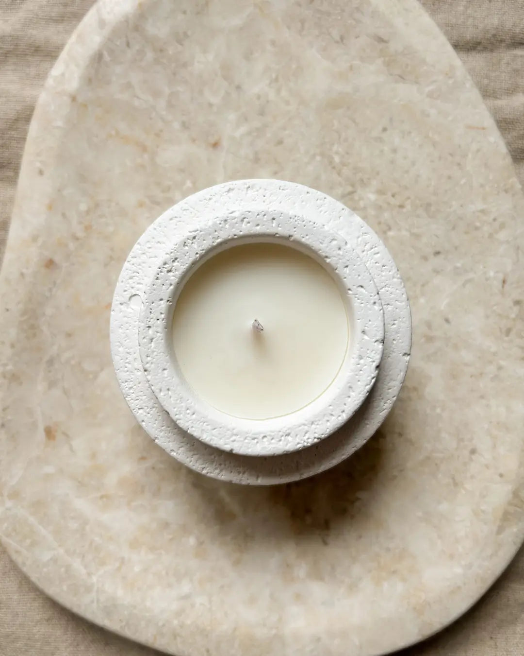 Candle in a stone holder on a textured stone surface