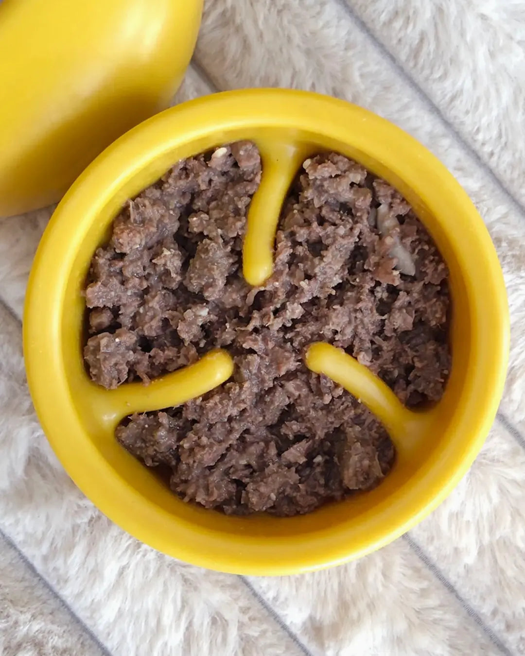 Yellow Lunoji dog slow feeder filled with wet dog food