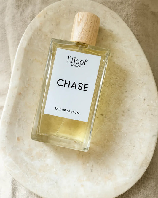 Perfume bottle labeled 'Chase' by L'floof on a beige plate