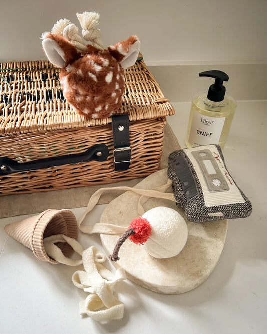 Collection of pet toys and a gift hamper on a white surface