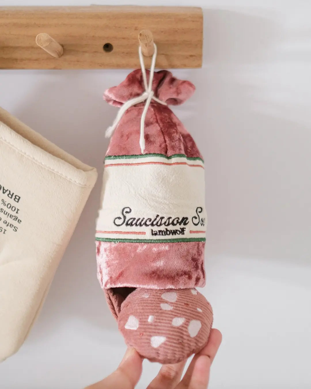 Saucisson sec-shaped plush dog toy on a white background