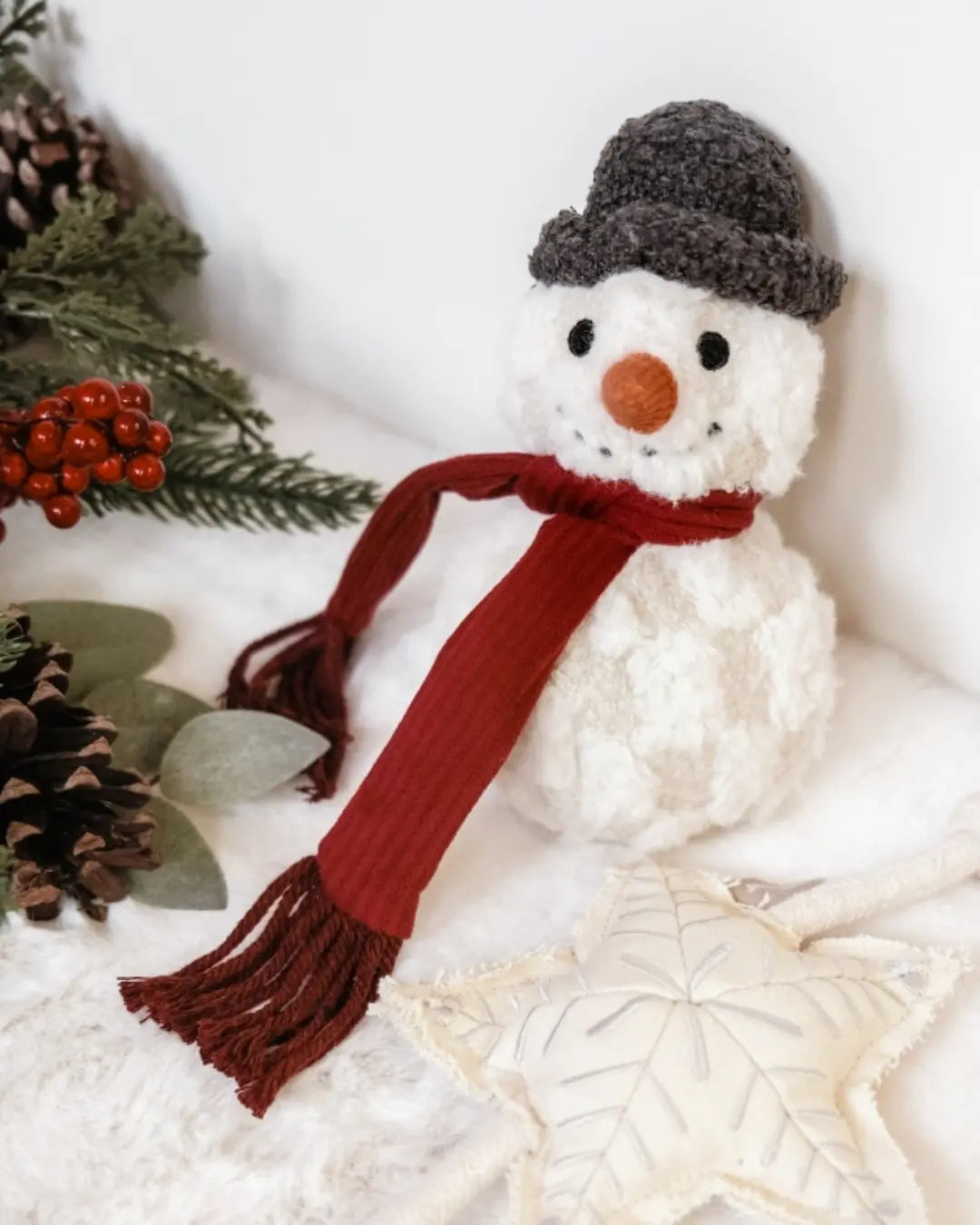 Plush snowman dog toy with a red scarf and grey hat on a white background
