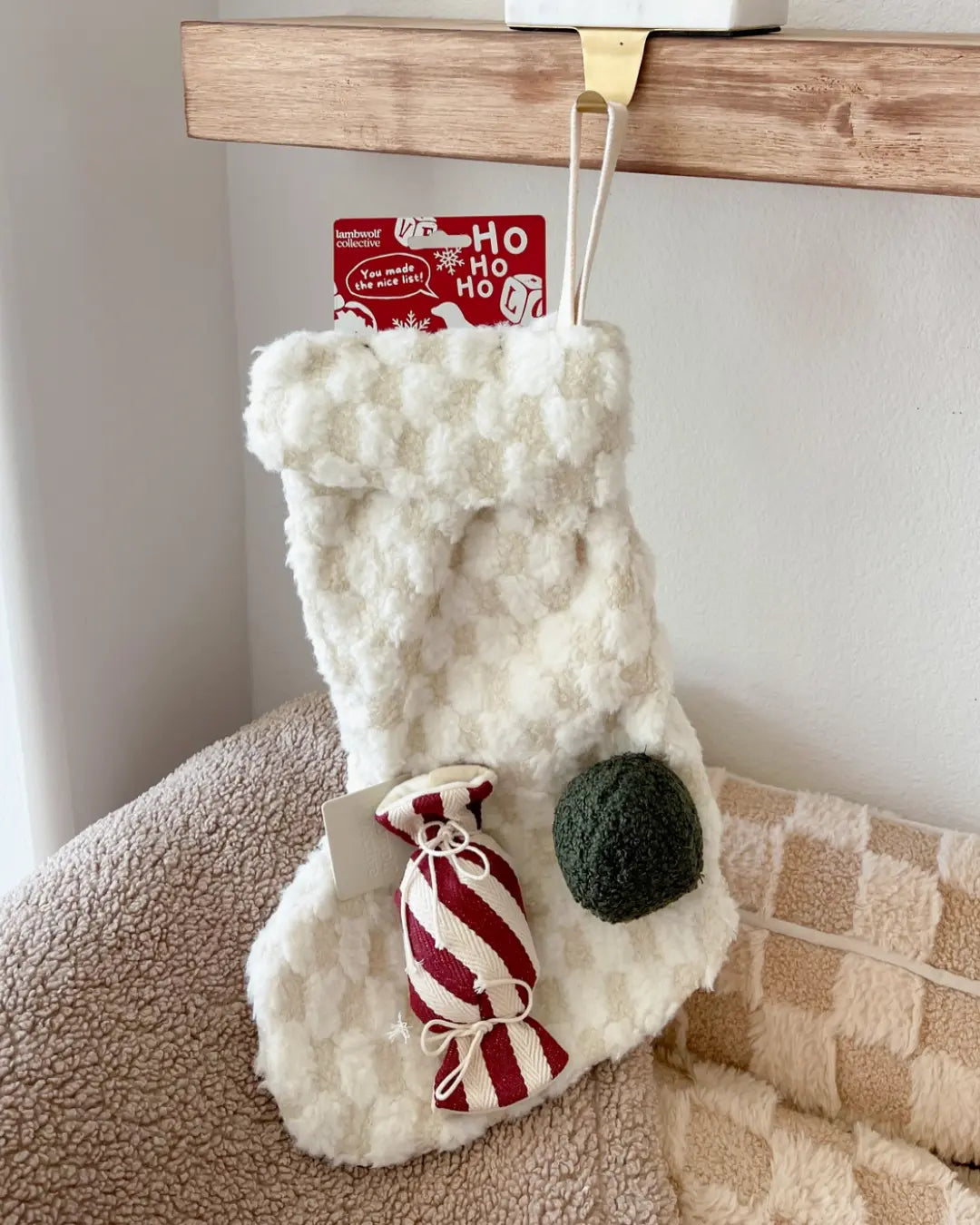 White fuzzy Christmas stocking dog toy with a striped candy dog toy and green squeaky ball