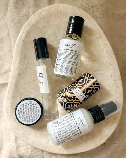 L'floof dog fur care products on a beige stone surface