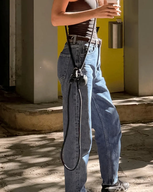 Person wearing blue jeans with a black rope dog lead and a silicone black treat pouch
