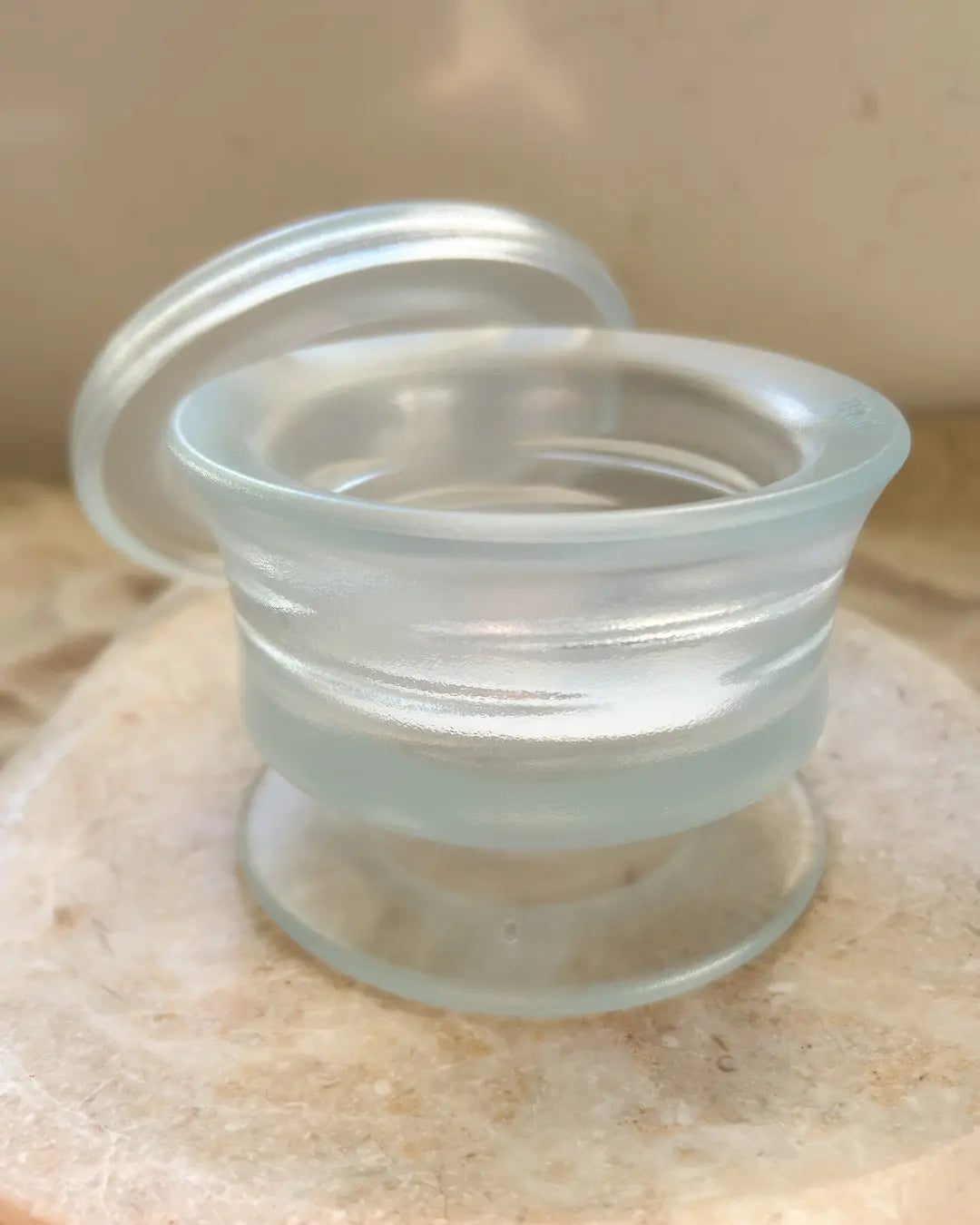Transparent dog frozen enrichment bowl with lid on a neutral background