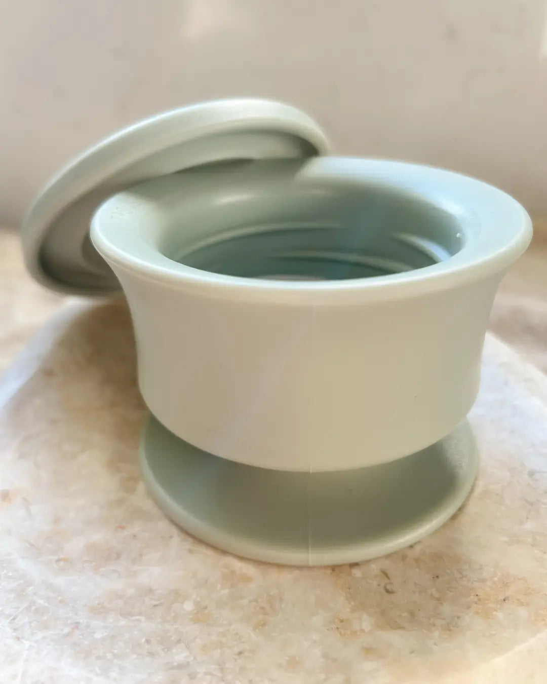 Sage green dog frozen lick enrichment bowl with lid on a neutral background