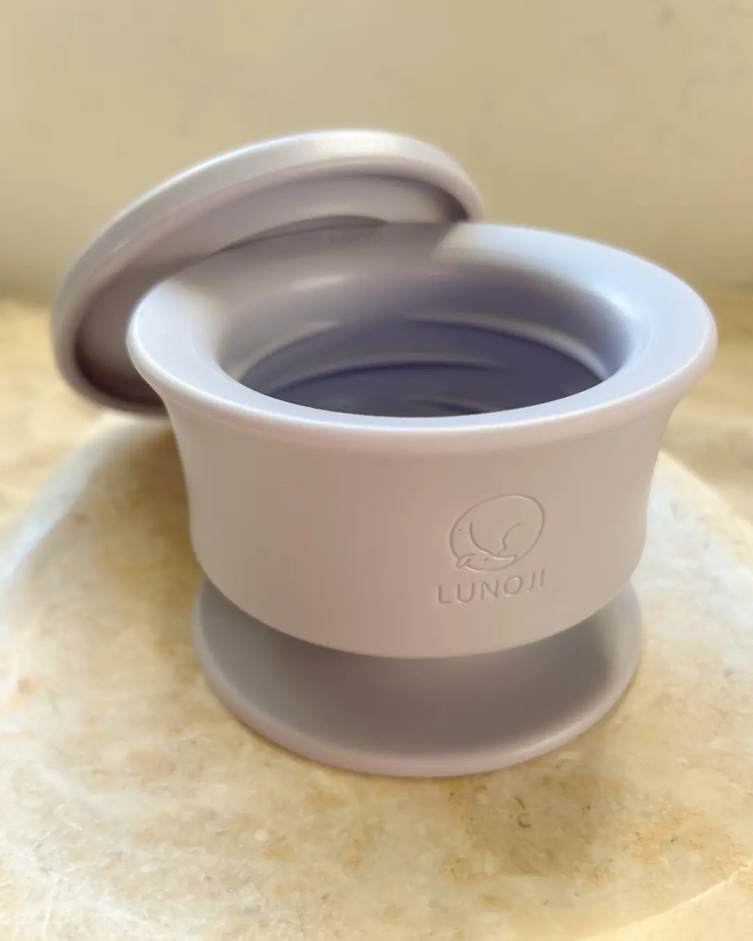 Lilac dog enrichment bowl with lid on a neutral background
